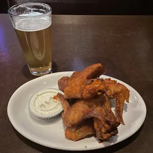 a plate of fried wings and a glass of beer