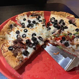 deep dish pizza: Canadian bacon. Spicy Italian sausage, pepperoni, sundried tomatoes, roasted red peppers, green peppers, &amp; black olives