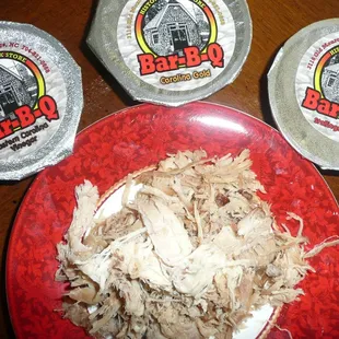 A portion of the1LB. bulk of pulled pork with the three different  sauce cups.