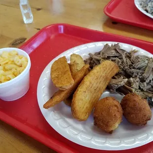 Brisket, mac and cheese, and potato wedges with hush puppies.