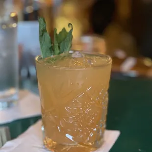 a glass of cocktail on a napkin