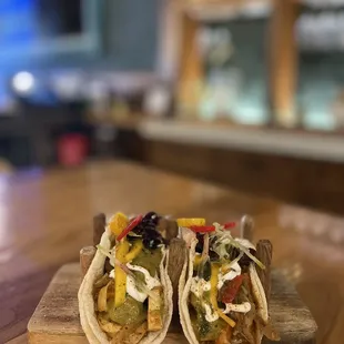 two tacos on a cutting board