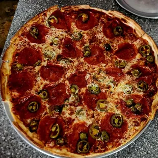 Thin, crispy crust, large pepperoni and jalapeno pizza.