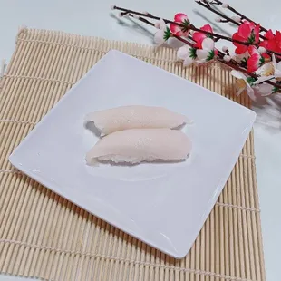 two pieces of sushi on a white plate