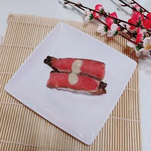 two slices of tuna on a white plate