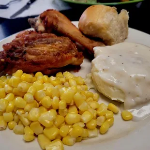 Fried chicken,  corn, mashed potatoes and gravy, and a roll.