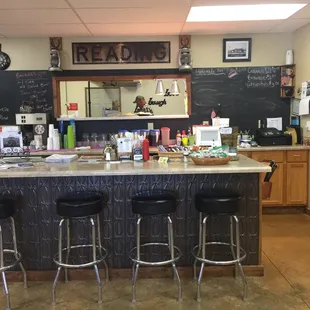 a counter with stools and a chalkboard