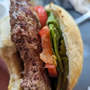 a hand holding a hamburger