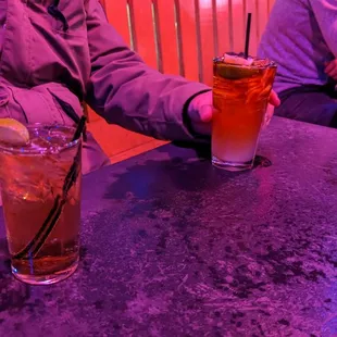 two people sitting at a table with drinks