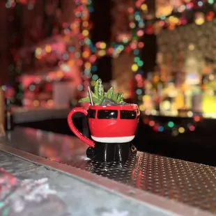 a coffee cup with a plant in it