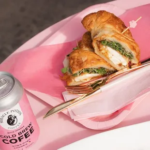 a sandwich and a drink on a pink tray