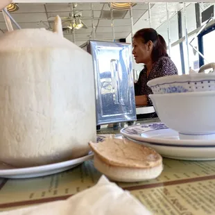 Young coconut drink next to bowls and plates to show how huge it was!