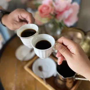 two people holding coffee cups