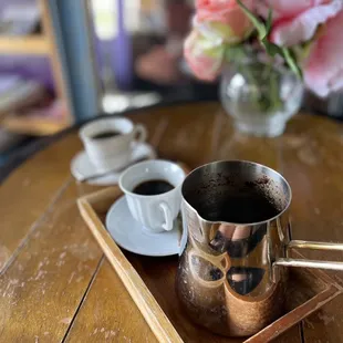 a coffee cup and saucer on a wooden tray