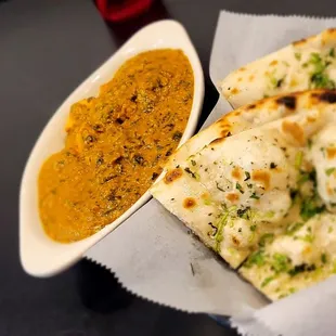 a plate of naan bread and a bowl of curry