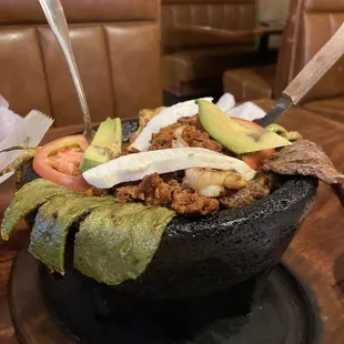 The molcajete up close! With chicken, steak, shrimp, cactus, and cheese. Plus a base of supeflavorful beans! Omgggg