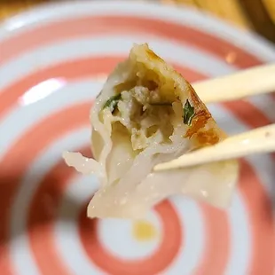 a piece of food on a plate with chopsticks