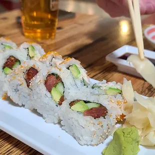 a plate of sushi with chopsticks