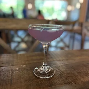 a purple drink in a coupe glass