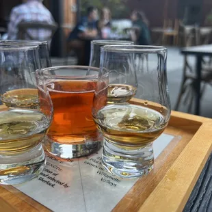 four glasses of whiskey on a tray