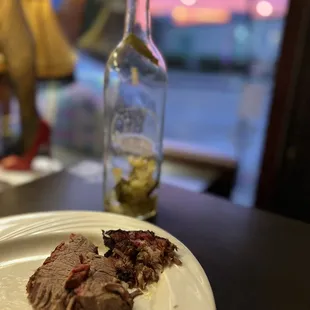 Brisket &amp; empty bottle of white sangria. With beautiful sunset in view.
