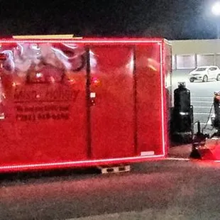 a red food truck parked in a parking lot