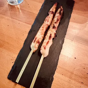 two skewers on a black plate