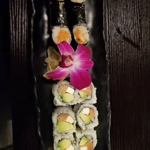 a plate of sushi with a flower