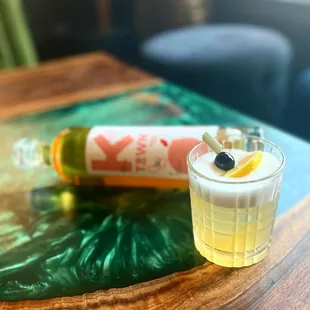 a shot of a drink and a bottle on a table