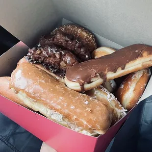 a person holding a box of donuts