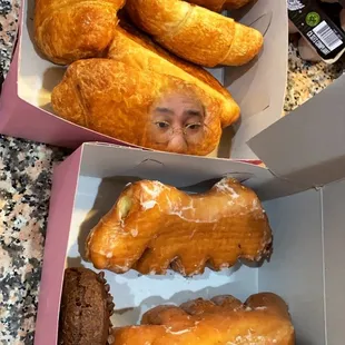 a woman&apos;s face in a box of doughnuts