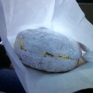 Lemon filled powder donut. The outside has a thin crunchy crust with soft airy dough on the inside. Your taste buds will break dance!