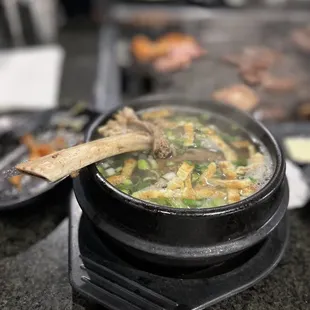 a pot of soup with a wooden spoon