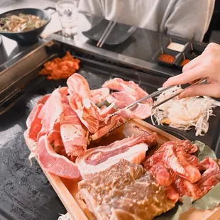 a person cutting meat on a cutting board