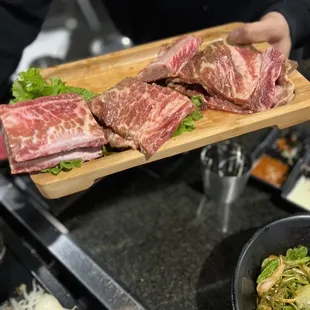 a person holding a cutting board with meat on it