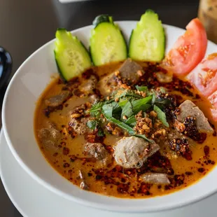 Pho Sa Te -  Rich, spicy beef broth with chili oil, peanut, cucumber, tomatoes, and fresh herbs