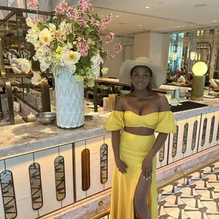 a woman standing in a yellow dress