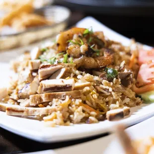 a plate of fried rice with meat and vegetables