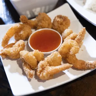 a plate of deep fried shrimp with dipping sauce
