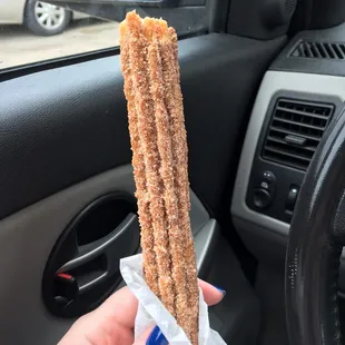 a hand holding a sugared donut