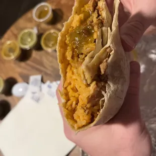 a hand holding a burrito