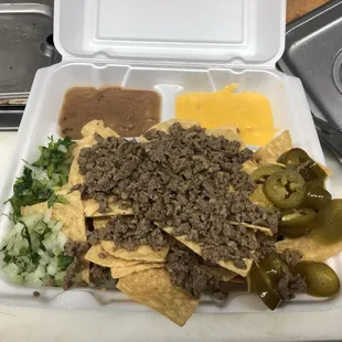 Delicous NACHOS, tortilla chips with homemade asada (steak) all the way