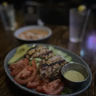 Caesar salad with grilled chicken and extra tomato, cucumber, onion, and avocado