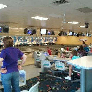 a woman standing in front of a bowling alley