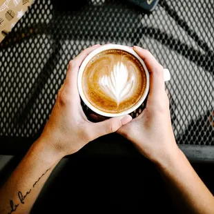 a person holding a cup of coffee