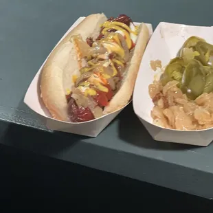 two hotdogs with relish and pickles