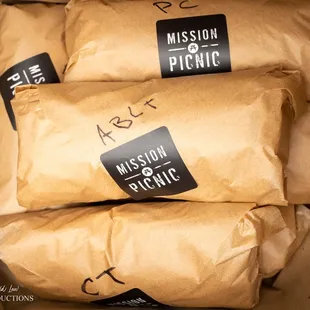 three bags of food wrapped in brown paper