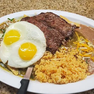 Spicy green chilaquiles with a steak (extra $), 2 eggs, beans and rice.