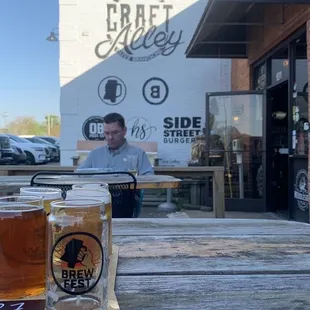 a man sitting at a picnic table with two beers