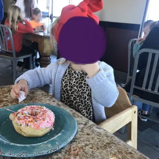 One of the grands enjoying her pink sprinkle donut